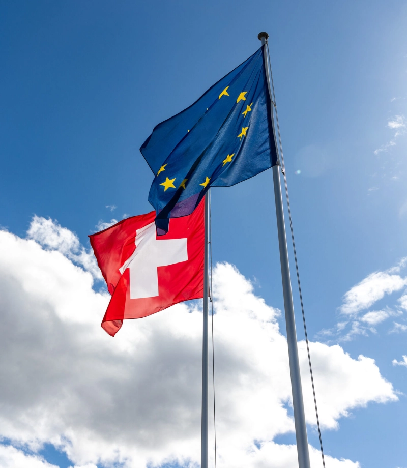 Flags of Switzerland and EU blowing in the wind