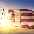 Jura canton of Switzerland flag textile cloth fabric waving on the top sunrise mist fog