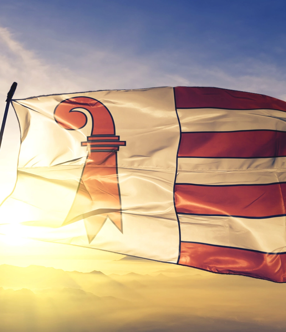 Jura canton of Switzerland flag textile cloth fabric waving on the top sunrise mist fog