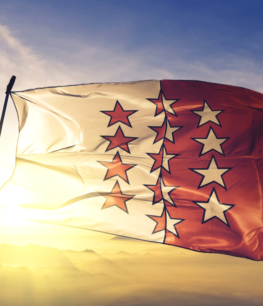 Valais canton of Switzerland flag textile cloth fabric waving on the top sunrise mist fog